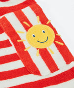 CLose up of the side pocket on the Frugi Harlyn towelling playsuit in red and white stripes showing sun patch detail