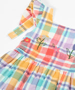 Frugi springtime dress in pastel check laid flat showing hyacinth embroideries on the upper body and frilled shoulders