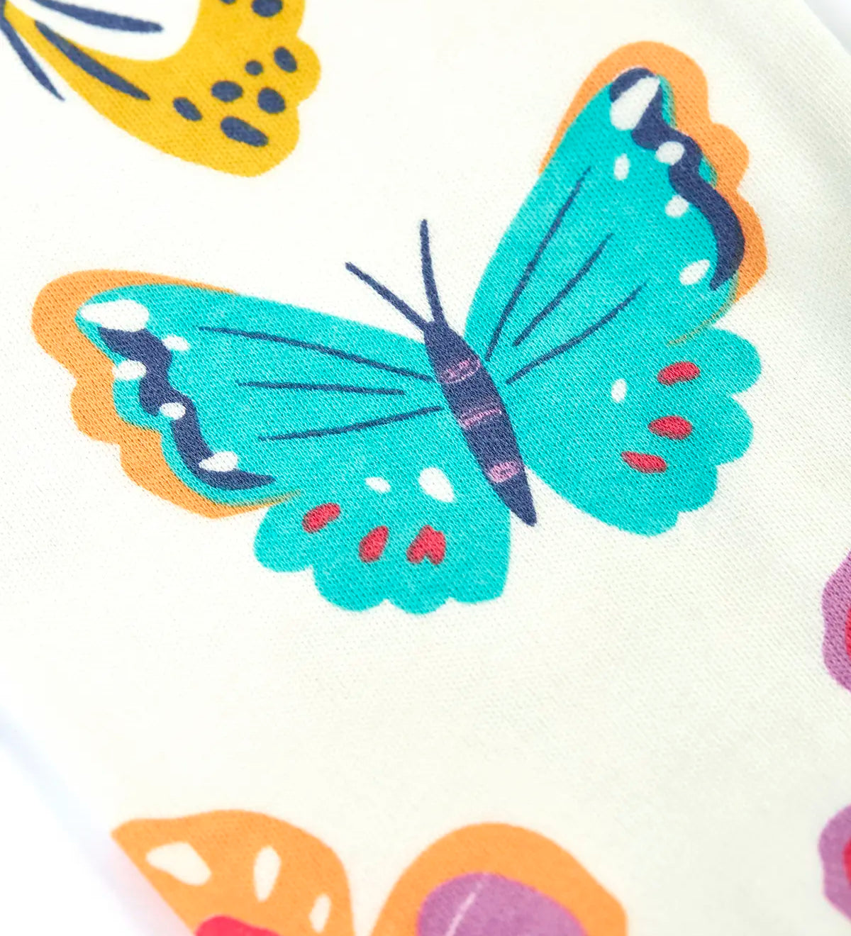 Close up of the repeating butterfly print on the Frugi 100% organic cotton Kernow pyjama set 