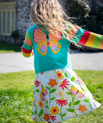 Child wearing Frugi cammie cardigan in light blue with rainbow striped sleeves showing large butterfly design on the back