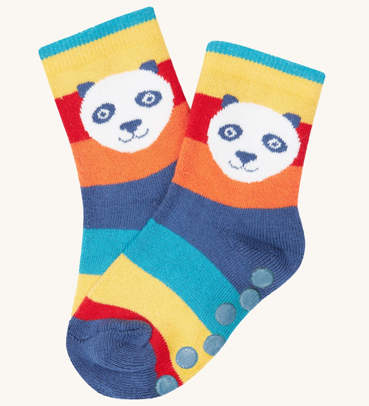 A close up of the rainbow striped sock with a panda's head design from the Frugi grippy 2 sock multipack in panda available at Babipur. Sock features blue circle grip panels on the sole.