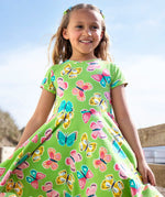 Child wearing Frugi 100% organic cotton spring skater dress in green with a repeating colourful butterfly print.