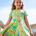 Child wearing Frugi 100% organic cotton spring skater dress in green with a repeating colourful butterfly print.