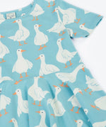 Frugi 100% organic cotton sunshine skater dress in light blue laid flat showing the repeating white goose print. 