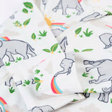 Frugi 100% organic cotton kimono style babygrow in white laid flat with a repeating elephant and rainbow print and cuff detail