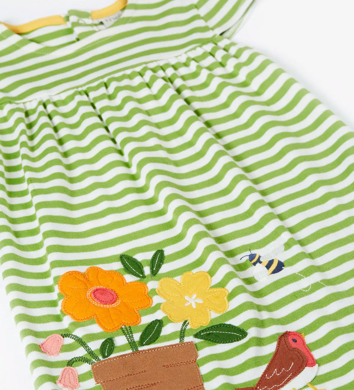 Frugi 100% organic cotton white and green striped Layla dress laid flat showing the flower, robin and bee patch on the skirt 