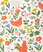 Close up of the Frugi 100% organic cotton white babygrow showing the repeating meadow inspired design