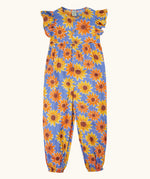 Frugi Lowenna jumpsuit in purple with a repeating sunflower print. Showing frilled shoulder and elasticated leg cuffs