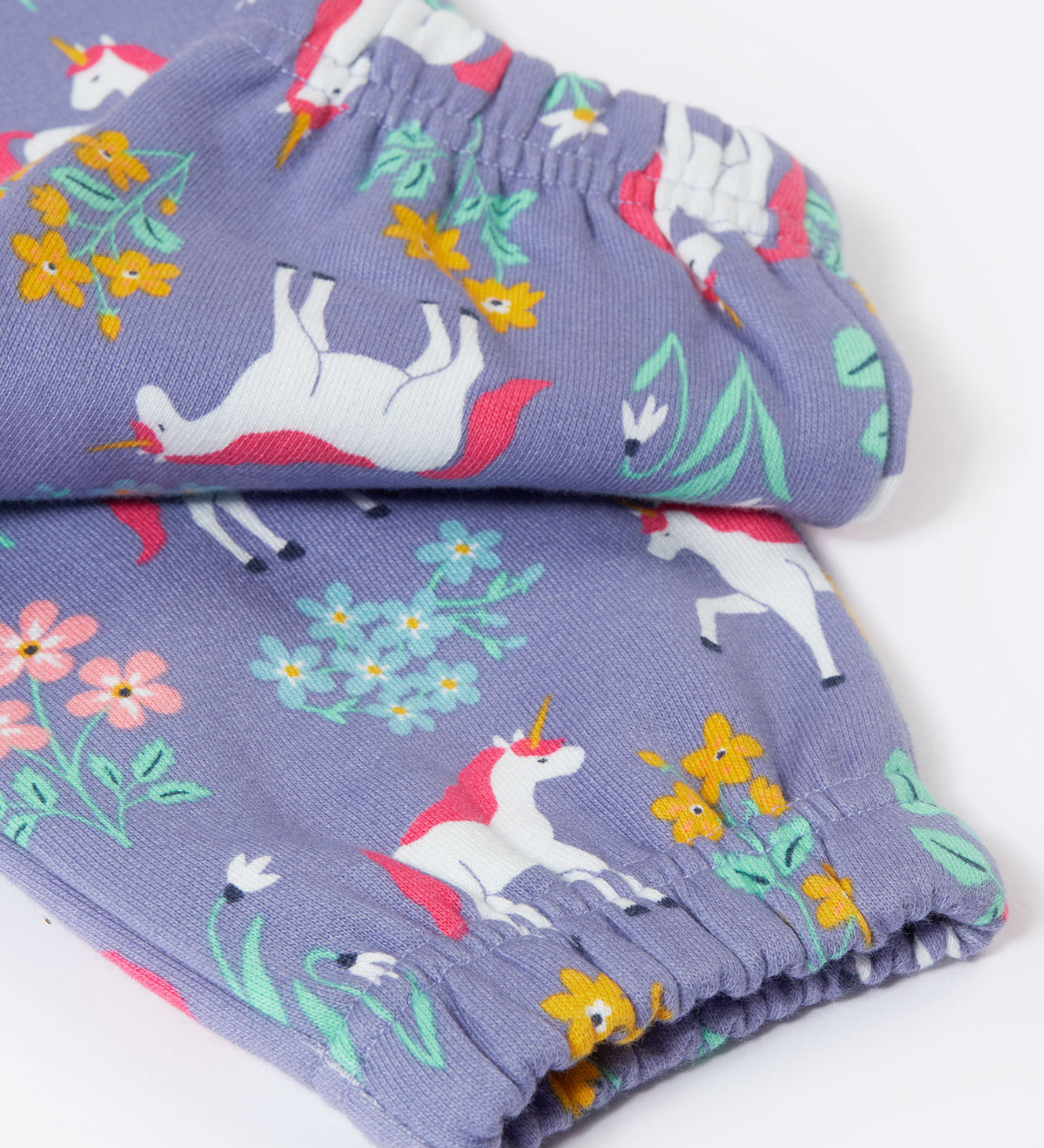 A close up of the elasticated cuffs on the Frugi malpas joggers in unicorn / floral available at Babipur. A GOTS organic cotton jogger in light purple with a playful unicorn and floral design. Features elasticated cuffs and side pockets.