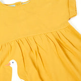 Close up of the yellow dress from the Frugi bumblebee goose gaggle outfit showing a goose patch on lower body