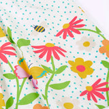 Close up of Frugi 100% organic cotton twirly dress in white with blue dots showing repeating floral, bee and butterfly design 