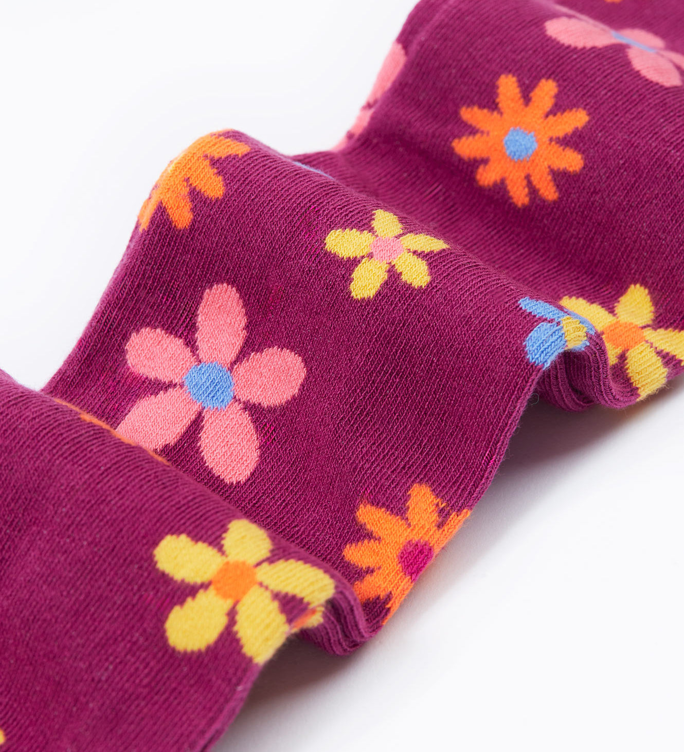 Frugi Norah tights in damson / retro floral available at Babipur. A GOTS organic cotton dark purple tights with a pastel coloured retro flower design and yellow contrasting panels
