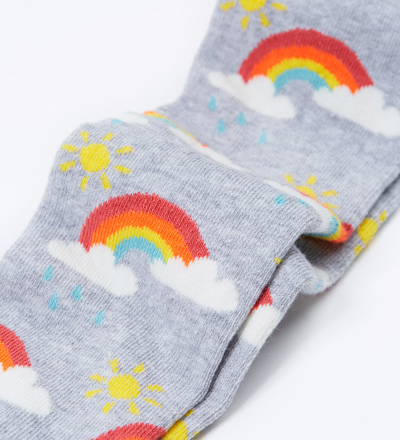 A close up of the rainbow print on the Frugi Norah tights in grey marl / rainbow available at Babipur. A GOTS organic cotton grey tights with a playful rainbow design and red contrasting heel and toe panels
