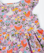 Frugi 100% organic cotton skater dress in violet purple laid flat showing the repeating meadow inspired print and frill detail