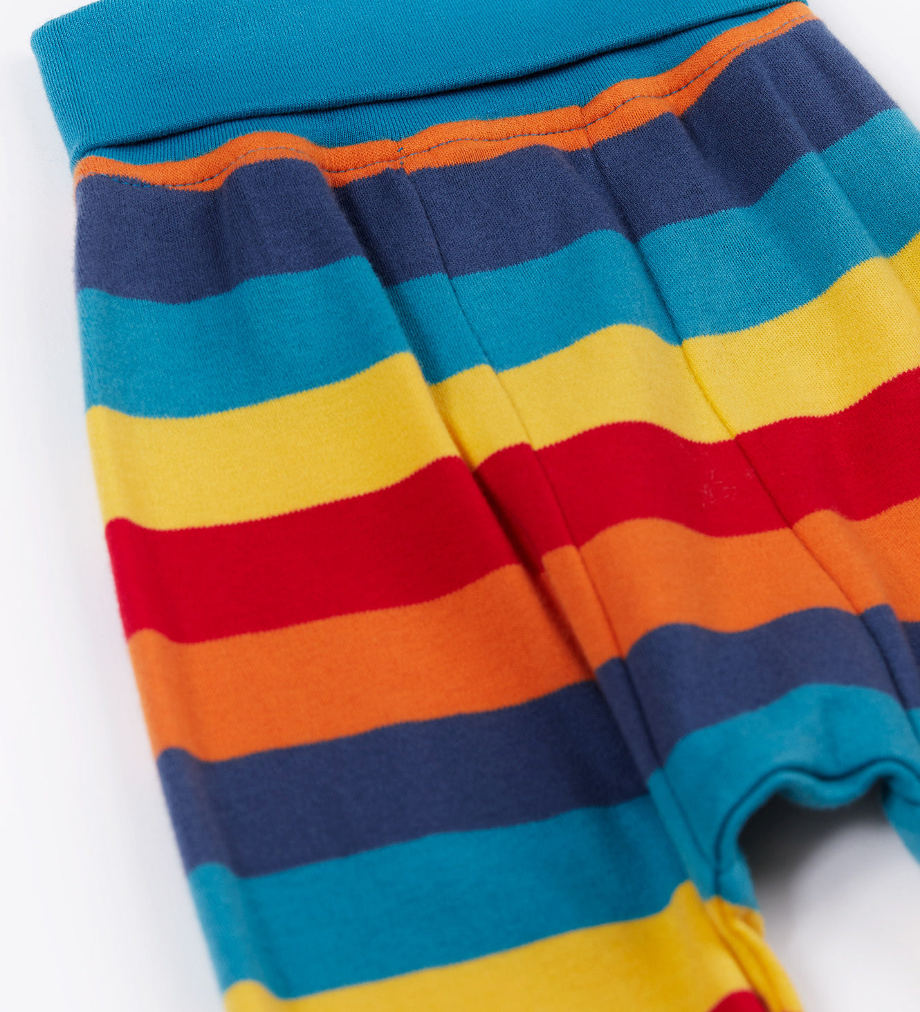Frugi parsnip pants in big rainbow stripe available at Babipur. A GOTS organic cotton bottom in bold rainbow inspired striped design. Features blue elasticated cuffs.