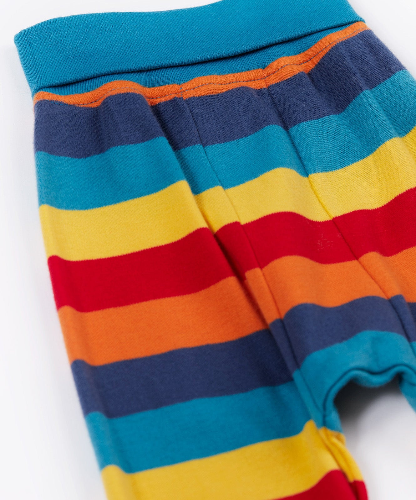 Frugi parsnip pants in big rainbow stripe available at Babipur. A GOTS organic cotton bottom in bold rainbow inspired striped design. Features blue elasticated cuffs.