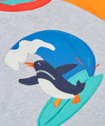 Close up of the Frugi 100% organic cotton short sleeve t-shirt in grey  Showing a surfing penguin patch on the front