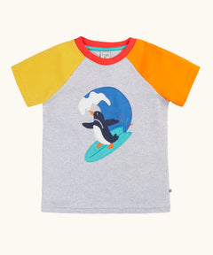 Frugi 100% organic cotton short sleeve t-shirt in grey with a yellow and orange sleeve. Showing a surfing penguin patch on the front