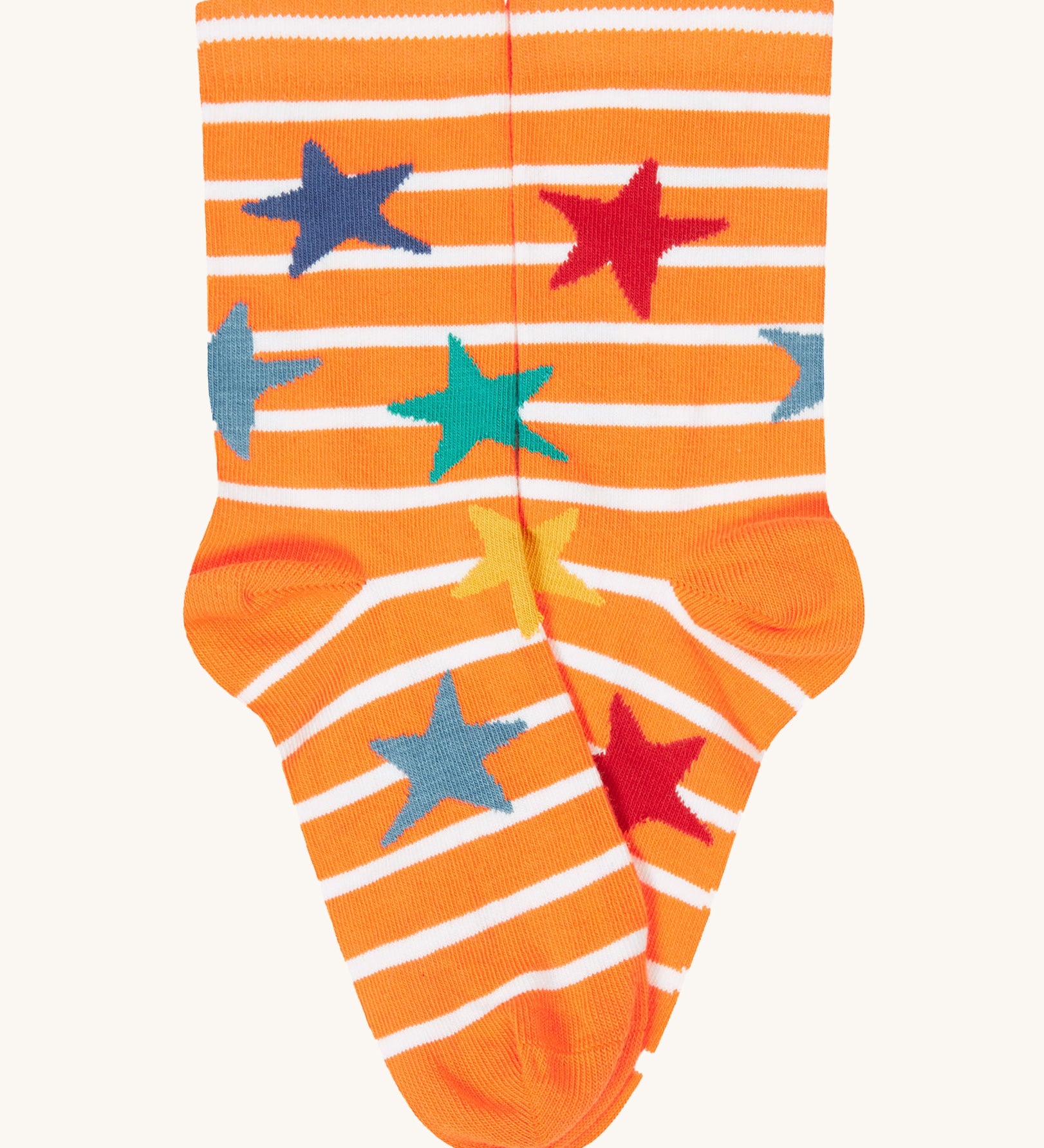 A close up of the orange and white striped sock with multicoloured stars from the Frugi rock my socks 3 pack in dragon skies available at Babipur. 