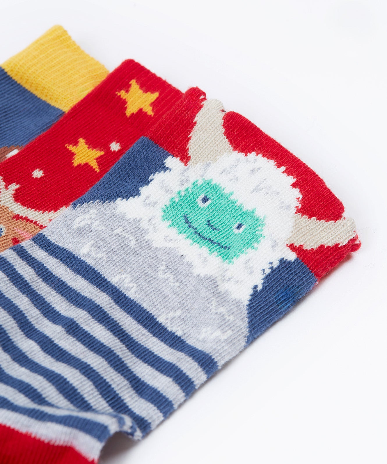 A close up of the yeti on one of the socks from the Frugi rock my socks 3 in festive multipack available at Babipur. GOTS socks in 3 different designs including a striped with a yeti, a red with reindeer and a blue sock with a cute robin design.
