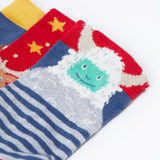 A close up of the yeti on one of the socks from the Frugi rock my socks 3 in festive multipack available at Babipur. GOTS socks in 3 different designs including a striped with a yeti, a red with reindeer and a blue sock with a cute robin design.