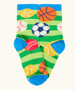 Frugi 100% organic cotton sock in green stripes with different repeating sport balls designs. Showing blue heel and toe panel