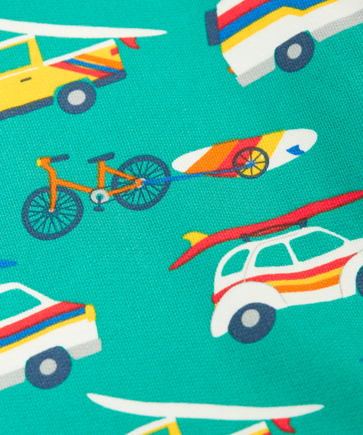 Close up of repeating beach theme vehicles designs on the Frugi 100% organic cotton shorts in light green