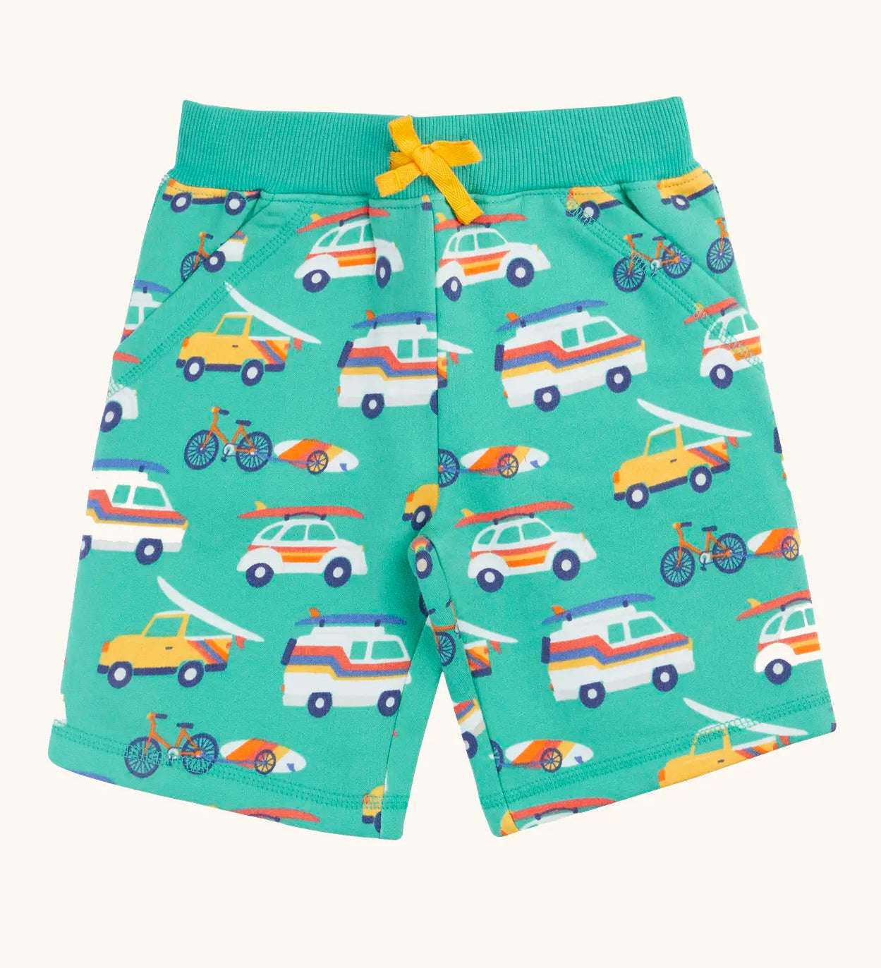 Frugi 100% organic cotton shorts in light green with repeating beach theme vehicles. Shows side pockets and yellow waist tie