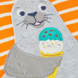 Close up of the playful seal patch on the Frugi 100% organic cotton short sleeve t-shirt in orange and white stripes 