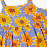 Frugi Sophie summer sleeveless dress in purple laid flat showing repeating sunflower design and shoulder straps