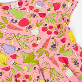 Frugi's 100% organic cotton spring skater dress in pink laid flat showing the repeating fruit and veg print 