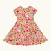 Frugi 100% organic cotton spring skater dress in pink with a repeating fruit and veg print.
