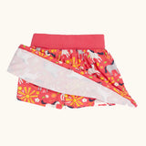 Frugi spring skort in coral pink with a repeating white and grey pony print showing the shorts underneath