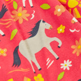 Close up of the repeating pony print on the Frugi 100% organic cotton spring skort in coral pink 