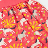 Frugi  spring skort in coral pink laid flat showing the repeating white and grey pony and sunshine print.