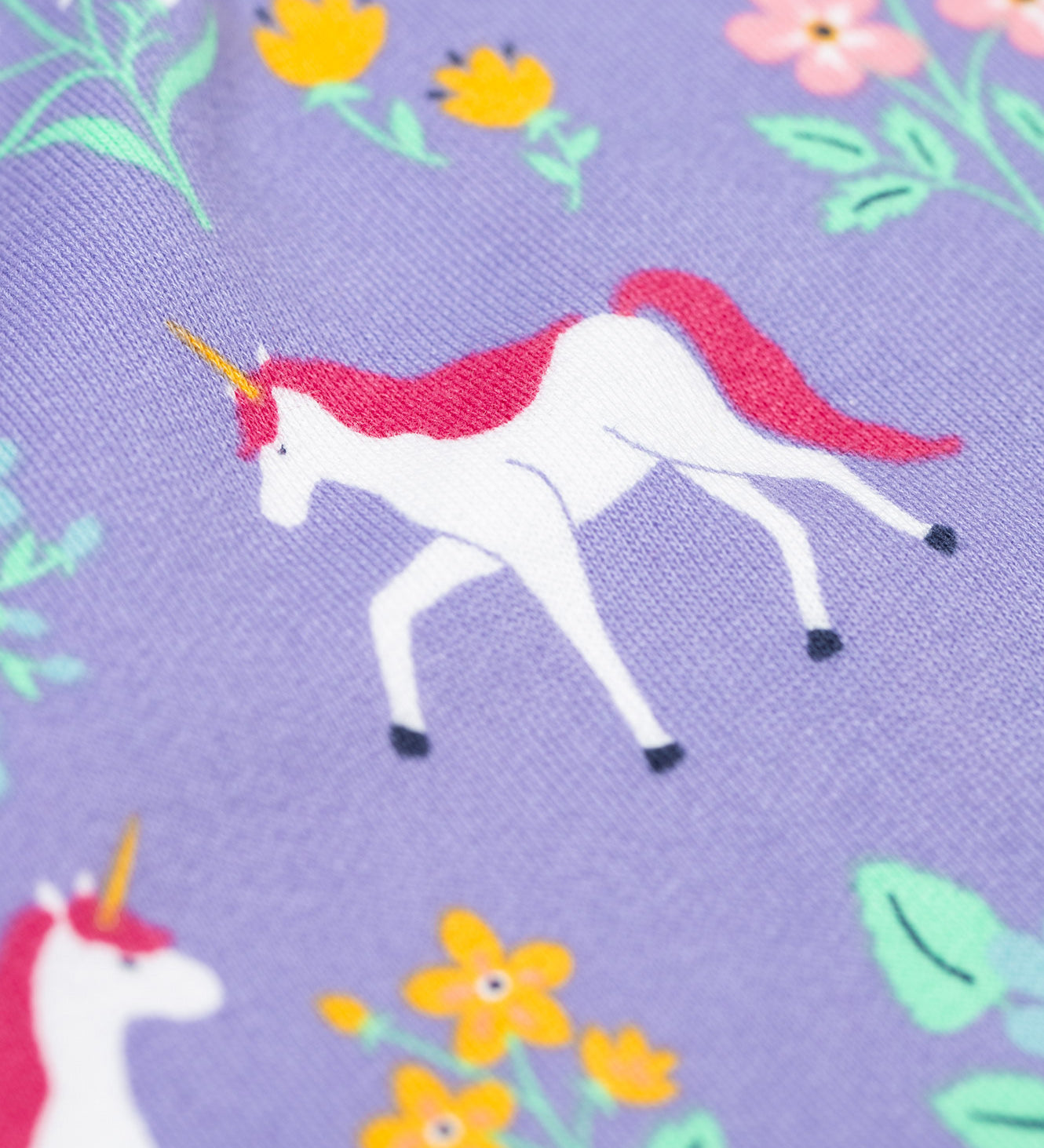 A close up of the unicorn featured on the print on the Frugi superb sweatshirt in unicorn floral available at Babipur. A soft GOTS organic cotton sweatshirt in lilac with a unicorn and floral print all over.