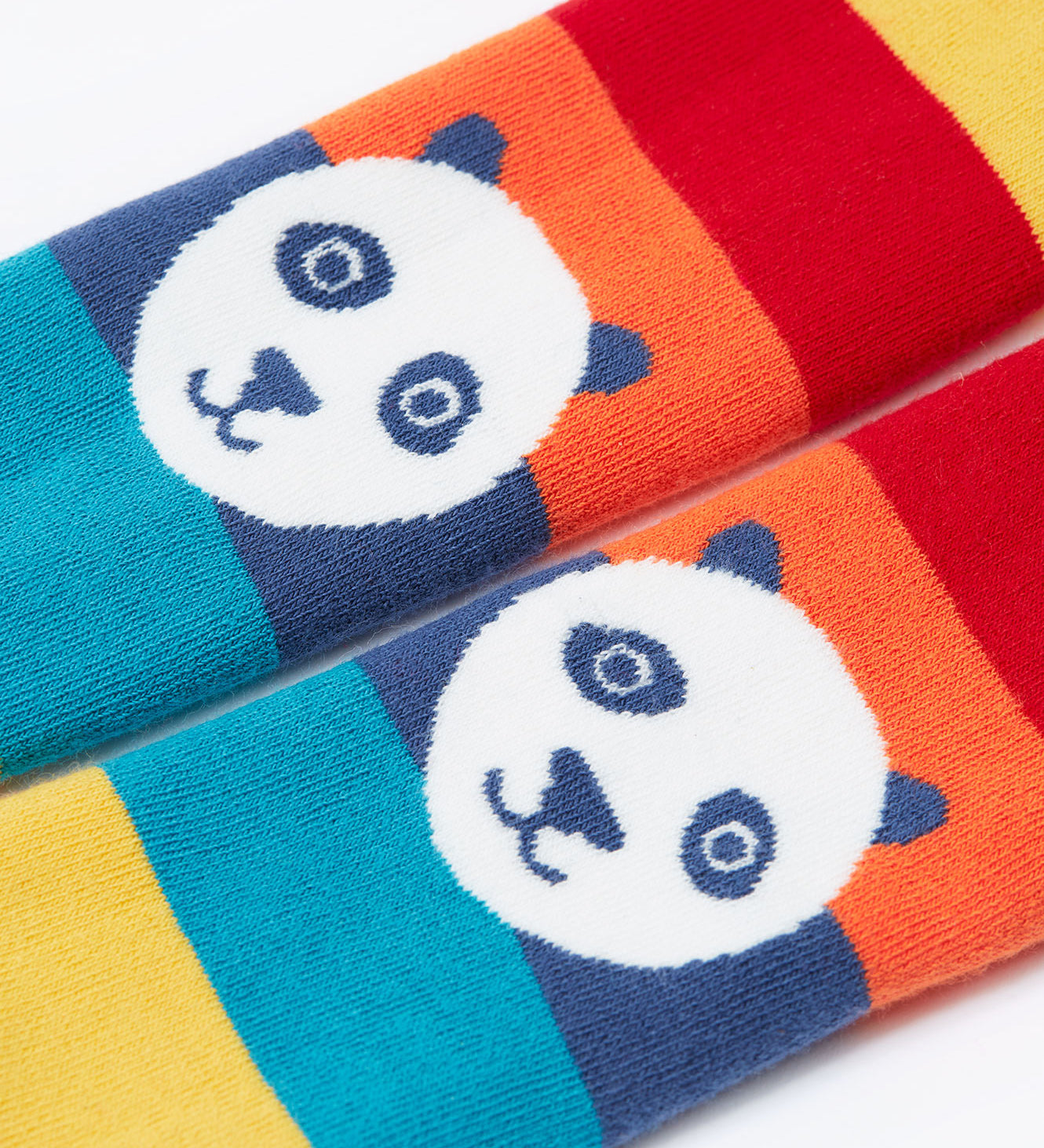 A close up of the pandas on the knees of the Frugi toasty tights in big rainbow stripes/panda available at Babipur. A GOTS organic cotton tights with bright and bold rainbow stripes with a panda design on the knees.