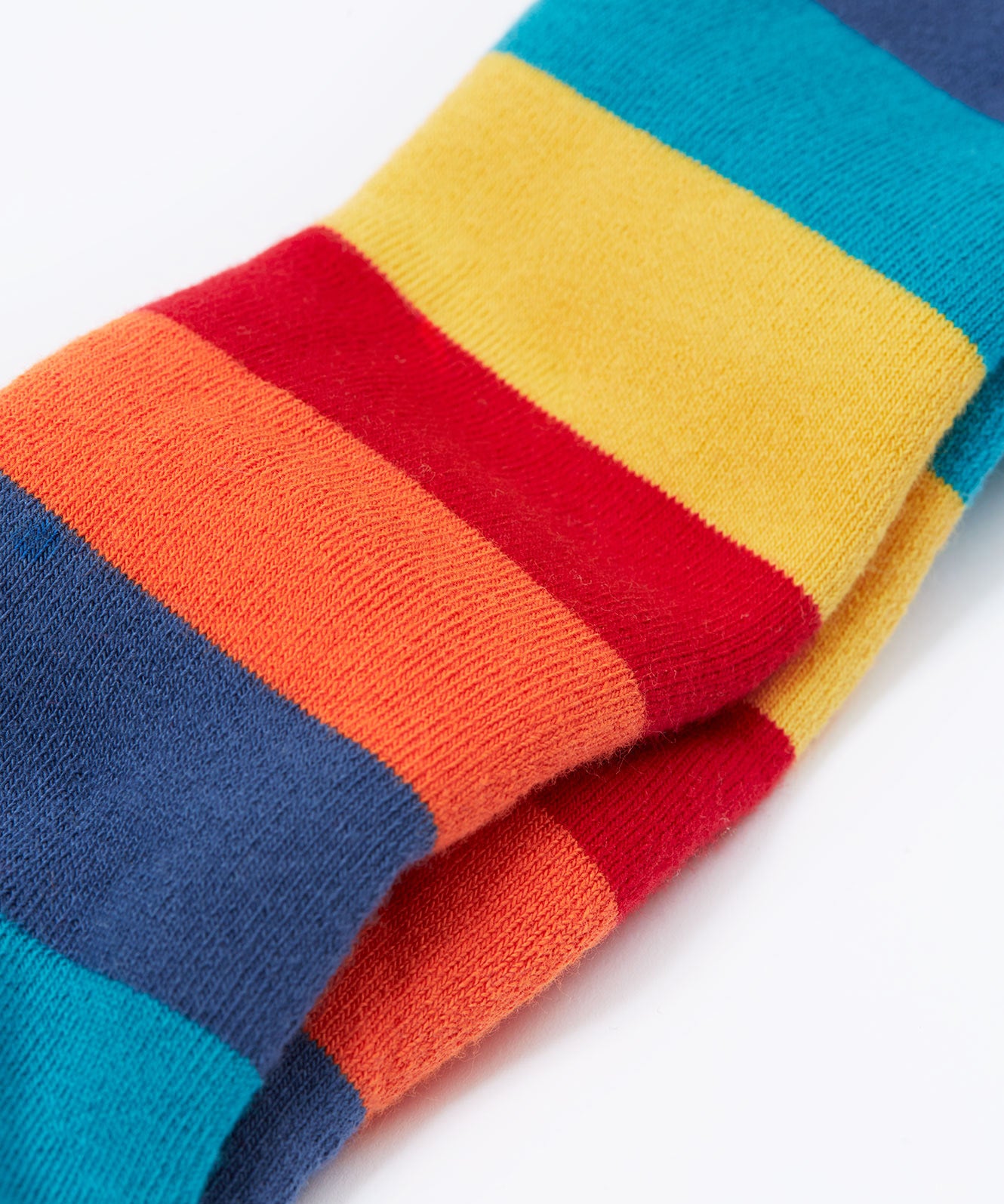 A close up of the material of the Frugi toasty tights in big rainbow stripes/panda available at Babipur. A GOTS organic cotton tights with bright and bold rainbow stripes with a panda design on the knees.