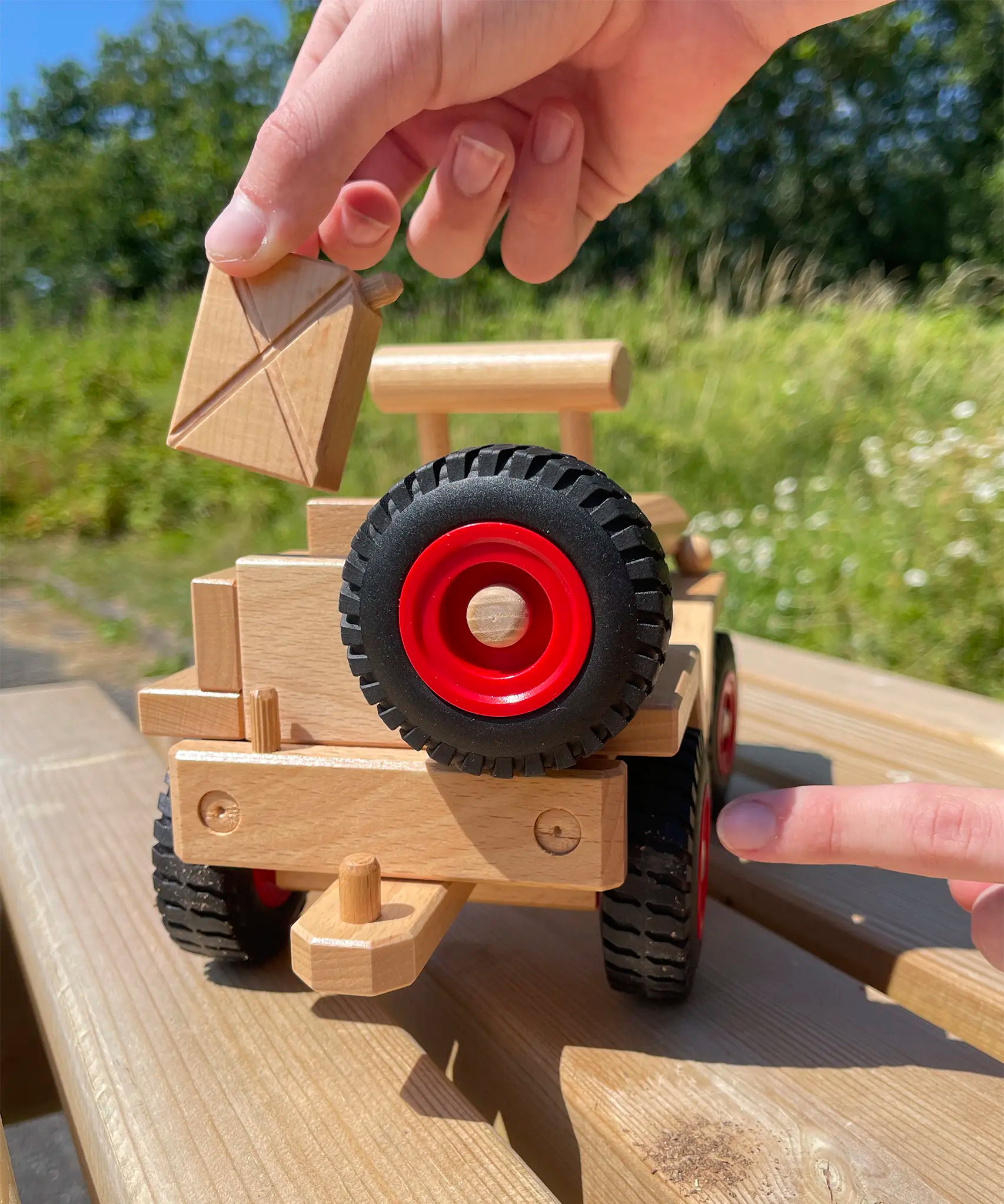 Fagus Jeep Wooden Car, with a spare spinning wheel on the back, a tow hitch for Fagus trailers and a detachable reserve jerry can.