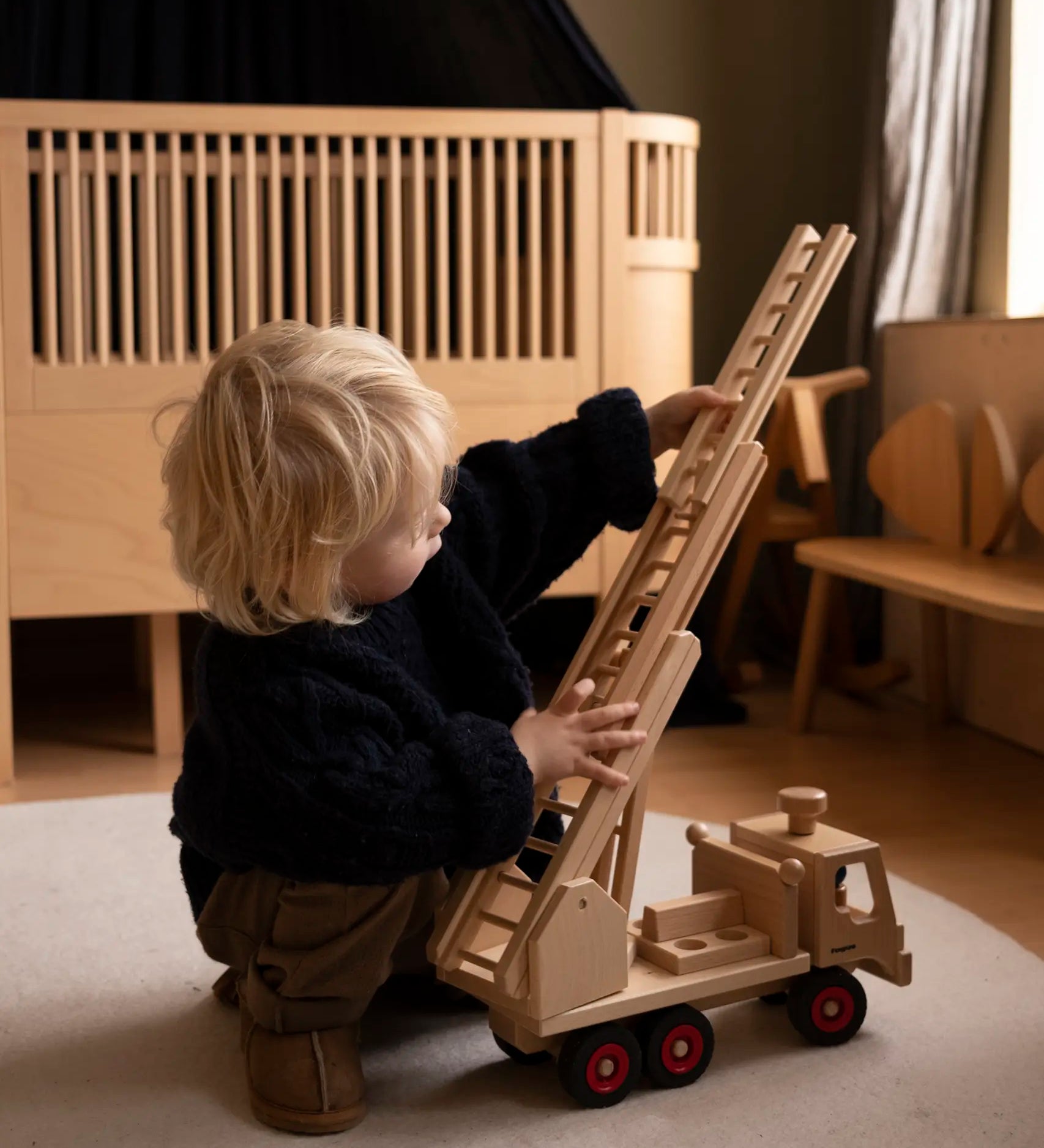 Fagus fire engine wooden toy featuring an extendable rotating 3-piece ladder, working steering and 6 peg doll figures.