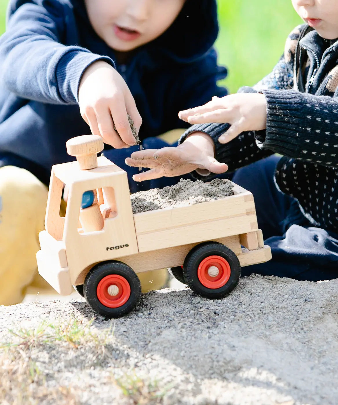 Fagus unimog, kids wooden toy truck with tow bar, working steering and rubber wheels, played with by kids outside.
