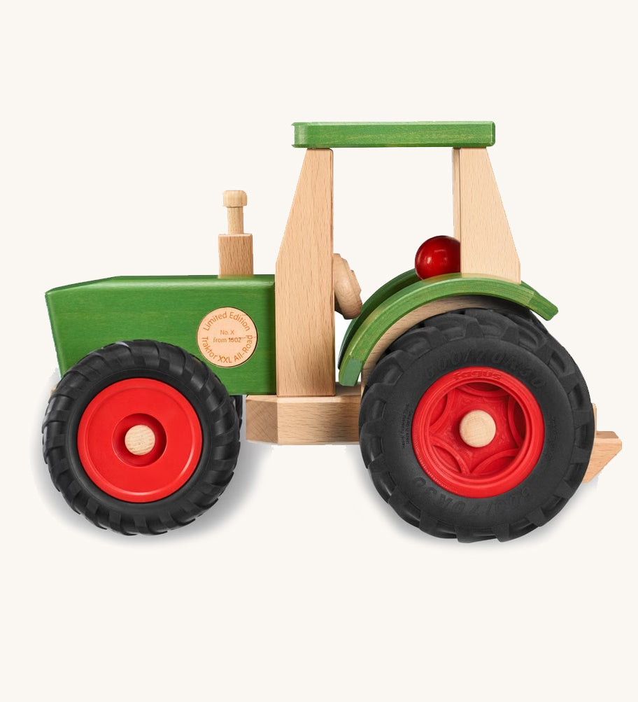 Fagus Wooden toy tractor with green body, red wheels, and beige seat on a white background