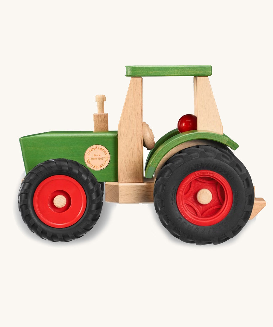 Fagus Wooden toy tractor with green body, red wheels, and beige seat on a white background