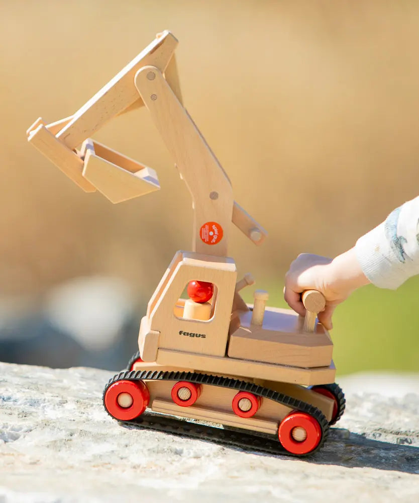 Fagus wooden excavator toy, handmade with grippy rubber tracks, an adjustable scoop and two peg dolls for small world play.
