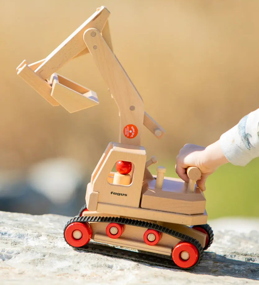 Fagus wooden excavator toy, handmade with grippy rubber tracks, an adjustable scoop and two peg dolls for small world play.
