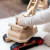 Fagus excavator toy, beautifully handmade from wood with grippy rubber tracks, an adjustable scoop and two peg dolls for small world play.