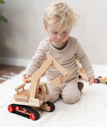Fagus excavator wooden toy featuring grippy rubber tracks, an adjustable scoop and two peg dolls, perfect for small world play.