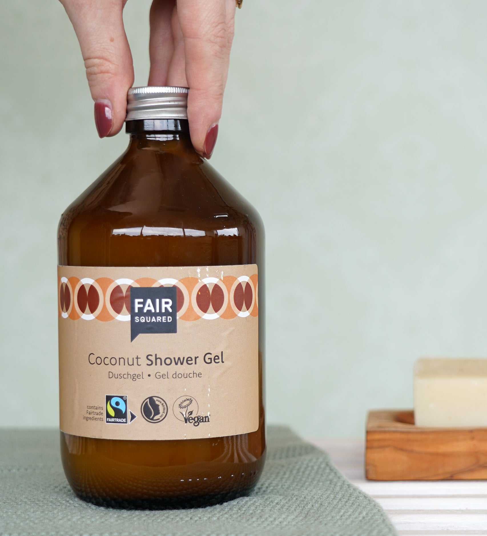 Plastic-free Fairtrade Coconut Shower Gel 500ml in a bathroom, by Fair Squared, available to buy at Babipur.
