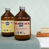 A glass bottle of Coconut Fair Squared Fairtrade Shower Gel 500ml in a bathroom - vegan, cruelty free and plastic free - for sale at Babipur.