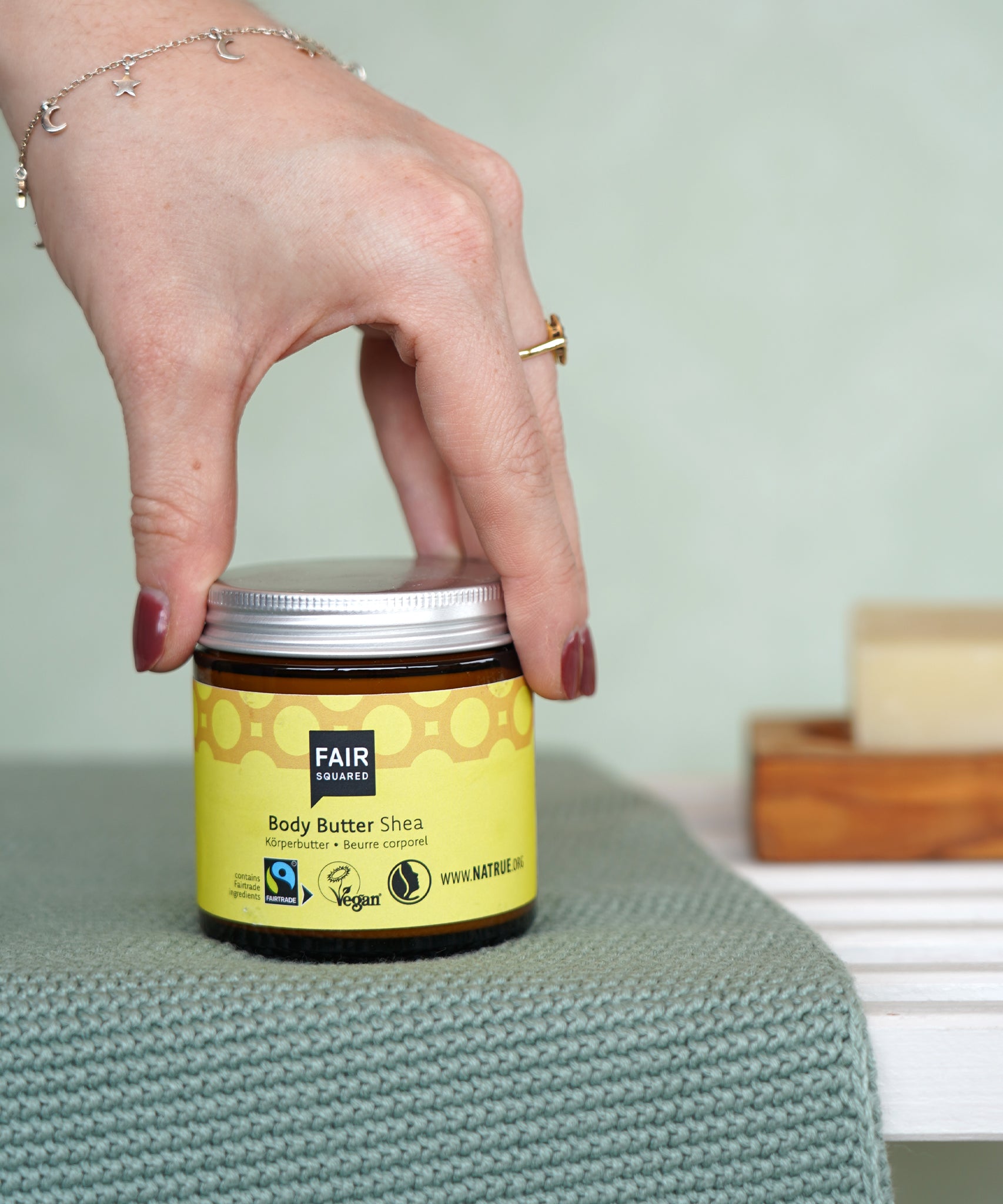 Jar of Fair Squared Fairtrade Shea Body Butter in a bathroom, made with vegan ingredients, for sale at Babipur.